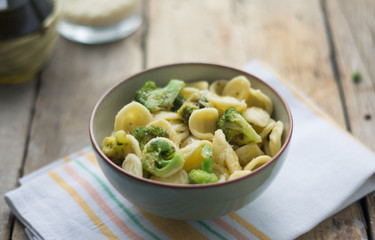 Homemade pasta orecchiette with broccoli, Italian suasage and parmesan on the wooden rustic table