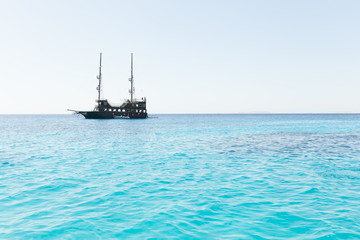 Obraz premium pirate ship on the horizon of blue sea