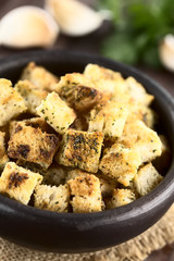 Freshly baked crunchy croutons seasoned with garlic and herbs in rustic bowl (Selective Focus, Focus one third into the bowl)