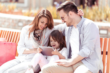 Obraz premium Young family using tablet in the city.