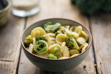 Homemade pasta orecchiette with broccoli, Italian suasage and parmesan on the wooden rustic table