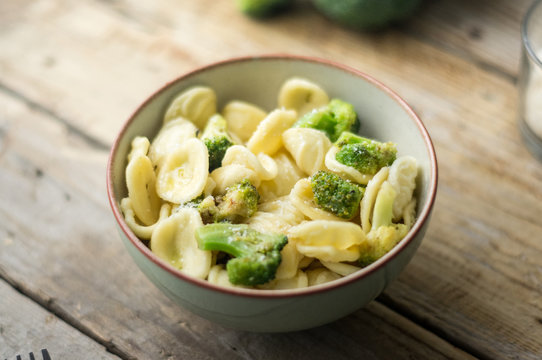 Homemade pasta orecchiette with broccoli, Italian suasage and parmesan on the wooden rustic table