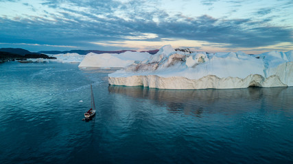Classic Greenland drone view. Aluminum yacht and largest icebergs field. 