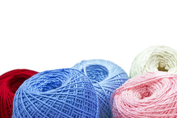 Knitting yarn on blue table against blurred background. Close up of multi colored woolen balls.