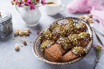 Obraz na płótnie Canvas Homemade chocolate cookies Madeleine with chopped pistachio nuts in metal basket. Holidays and party food concept with copy space.
