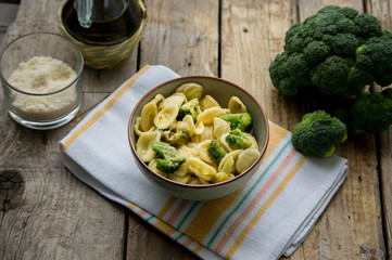 Homemade pasta orecchiette with broccoli, Italian suasage and parmesan on the wooden rustic table