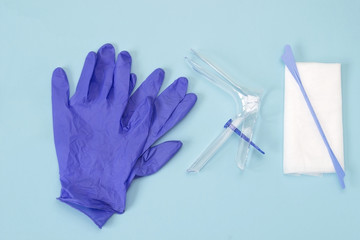 An overhead photo of the vaginal speculum, white napkin, medicine gloves and spatula. Medical plastic tool for holding open the vagina during medical investigation. Feminine woman health diagnosis - 196898538