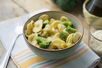 Homemade pasta orecchiette with broccoli, Italian suasage and parmesan on the wooden rustic table