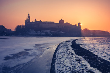 Krakow, Poland, Wawel Castle and Wawel cathedral in the winter over frozen Vistula river, sunrise
