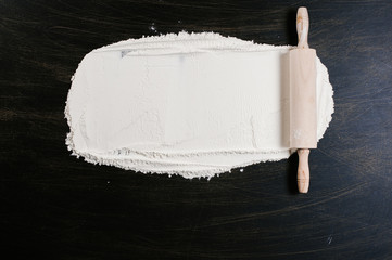 Concept of traditional, homemade baking and cooking with a rustic rolling pin spread with flour...