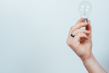 Man&rsquo;s hand holding a light bulb