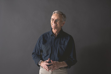 Portrait of old man expressing happiness while gesticulating hands. Cheerful mature employer concept