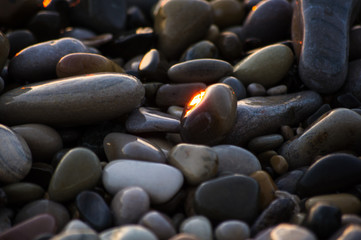 pebble stones on the sea beach, the rolling waves of the sea with foam