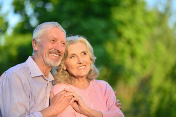 Happy elder couple hugging outdoors