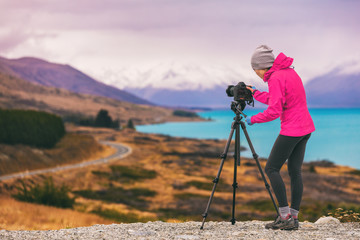 Photographe de voyage woman shooting photo nature paysage de montagne à Peter& 39 s Lookout, Nouvelle-Zélande. Touriste en vacances d& 39 aventure avec équipement photo, appareil photo reflex sur trépied au crépuscule.