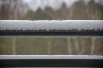 Snow is sticked on a balcony railing