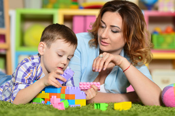 Fototapeta premium Young mother playing with son