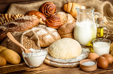 Assortment of baked bread on wooden table background