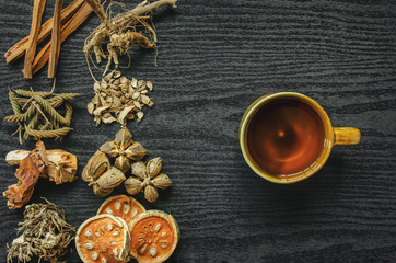 Dried herbs and Ginseng, Top view of Thai herbs and ginseng on wooden floor. Slices of dries root for make a herb juice on the dark table.