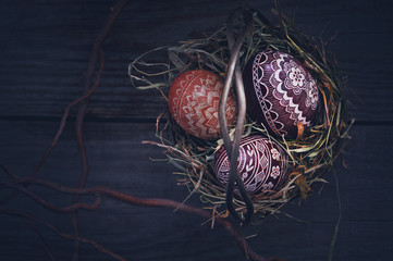 Easter eggs in a metal basket on a wooden table