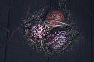 Easter eggs in a metal basket on a wooden table