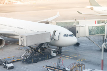 Jet aircraft docked in international airport. special truck unloads cargo from the aircraft