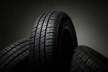 New and unused car tires against dark background
