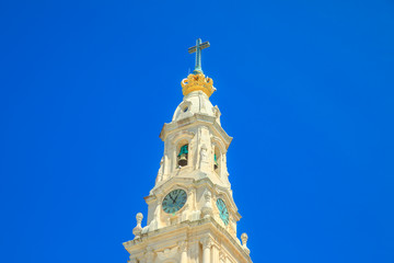 Bell tower of Sanctuary of Our Lady of Fatima in blue sky. Basilica of Nossa Senhora is one of the most important shrines of the world dedicated to Virgin Mary and biggest pilgrimage Site in Portugal.