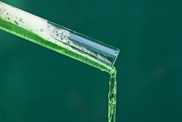 the green liquid is poured out of the glass tube