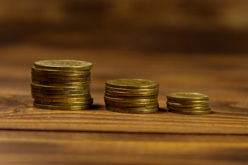 Stacks of golden coins on wooden background
