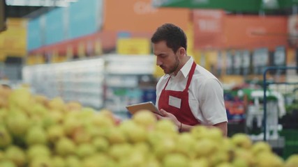Portrait seller man use tablet computer in supermarket vegetable business beautiful fresh produce retail shop worker food choosing young grocery healthy mall model shopping product putting small work