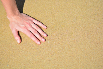 Fototapeta na wymiar the girl is hand on the sand with place for text
