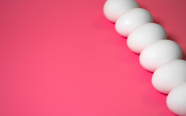 Minimal Easter concept. Perspective. Front view. White eggs on pink background. Close up. Copy space.
