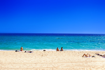 Summer beach with people taking sunbath on golden sand. 