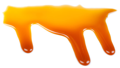 Caramel sauce isolated on white background close up. Flowing Butterscotch toffee caramel liquid .