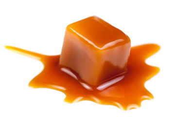 Caramel candies with caramel sauce isolated on a white background close up.