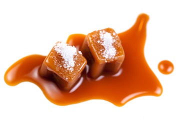 Caramel candies with caramel sauce isolated on a white background close up.