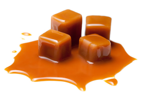 Caramel candies and caramel sauce isolated on a white background close up. 