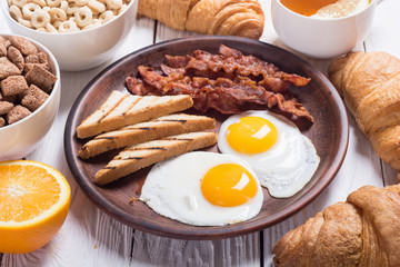 Breakfast with eggs , bacon and croissants