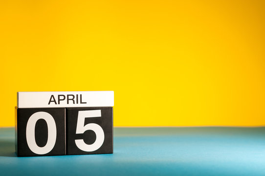 April 5th. Day 5 of april month, calendar on table with yellow background. Spring time, empty space for text