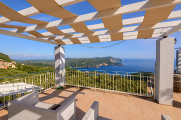 Restaurant terrace with view of beautiful bay of Palaiokastritsa. Corfu Island, Greece.