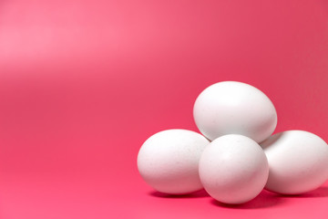 Easter minimal concept. Front view. White farm chicken eggs on pink background. Close up. Copy space.