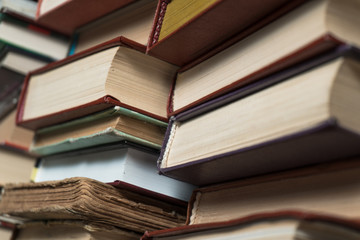 Many books in a bookstore or library on wooden background with copy space