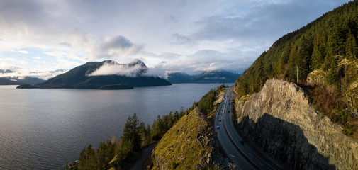 Aerial panoramic view of the Sea to Sky Highway in Howe Sound during a vibrant sunny day. Taken North of Vancouver, British Columbia, Canada.