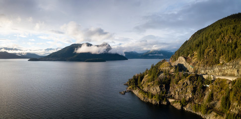 Aerial panoramic view of the Sea to Sky Highway in Howe Sound during a vibrant sunny day. Taken North of Vancouver, British Columbia, Canada.