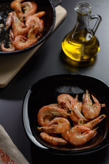 Shrimp in a black plate with olive oil
