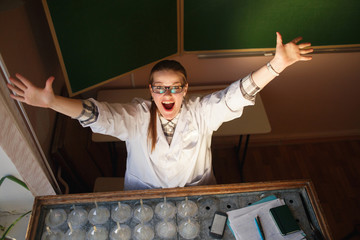 Happy female scientist lifting her hands in her laboratory