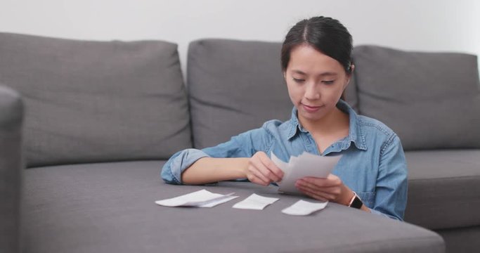 Housewife sorting the receipt to calculate the spending of daily life