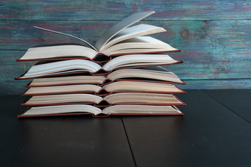 Open book hardback on Stack books on wooden background. Back to school with copy space.