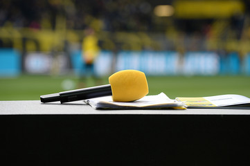 Gelbes Mikrofon auf TV Moderationspult im Stadion © Marcel Paschertz